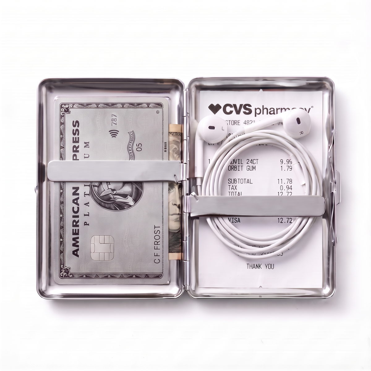 Tin cardholder wallet open, holding a metal credit card, a folded banknote, wired earbuds and a receipt